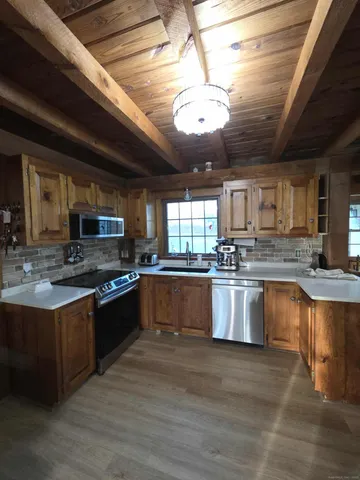 a large kitchen with stainless steel appliances granite countertop a stove granite counter tops and white cabinets
