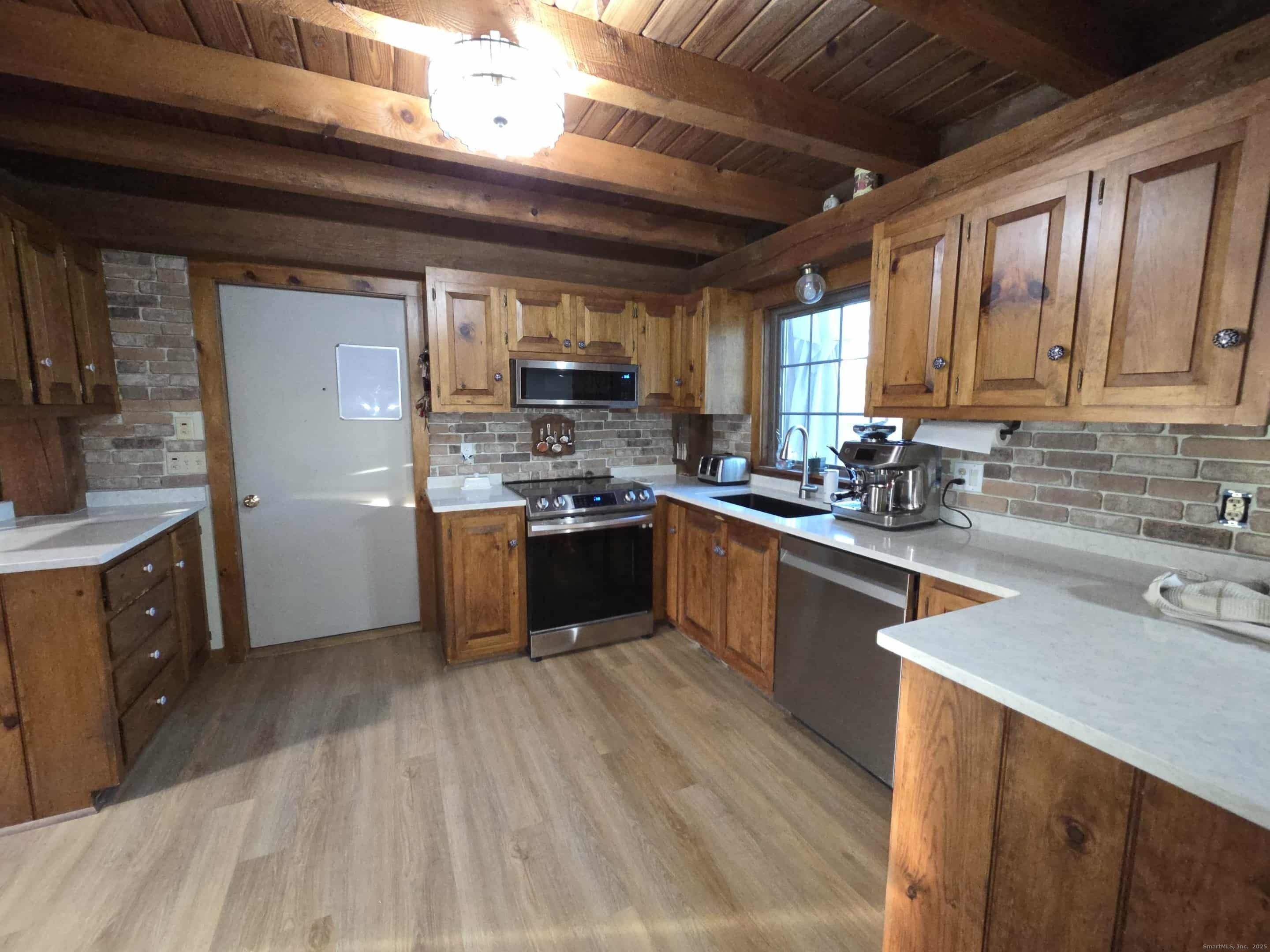 145 Perrin Road Woodstock, CT 06281 - Photo 4 of 38 a kitchen with stainless steel appliances a sink a stove a refrigerator cabinets and a window