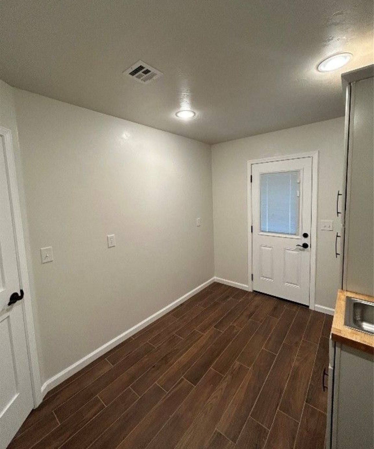 900062 South 3320 Road Wellston, OK 74881 - Photo 10 of 11 Wood-finish tile flooring, recessed ceiling lighting, a white paneled door with privacy glass, built-in cabinetry with a stainless steel sink, and wood countertops