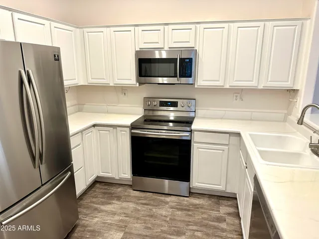 a kitchen with stainless steel appliances a refrigerator stove and microwave