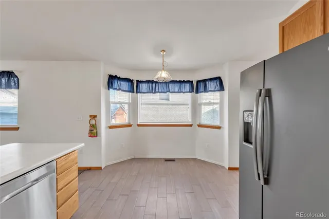 a view of empty room with a kitchen