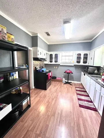 a living room with stainless steel appliances furniture and a flat screen tv