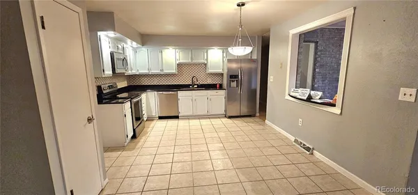 a kitchen with stainless steel appliances a refrigerator and a stove top oven