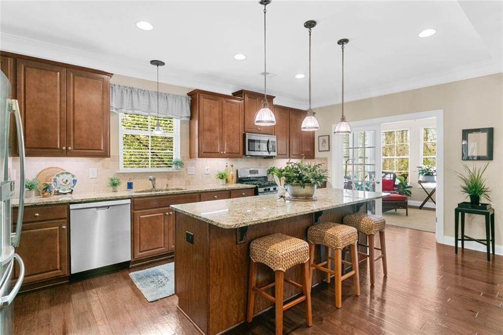 559 Bishopton Street Southeast Grayson, GA 30017 - Photo 15 of 34 a kitchen with stainless steel appliances granite countertop wooden floor sink stove and wooden cabinets