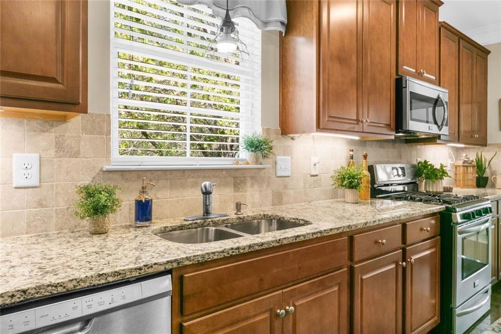 559 Bishopton Street Southeast Grayson, GA 30017 - Photo 18 of 34 a kitchen with stainless steel appliances granite countertop a sink a counter space and cabinets