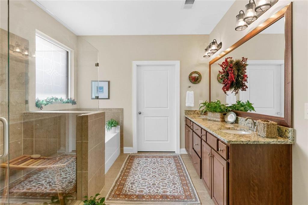 559 Bishopton Street Southeast Grayson, GA 30017 - Photo 25 of 34 a bathroom with a granite countertop sink a mirror and shower