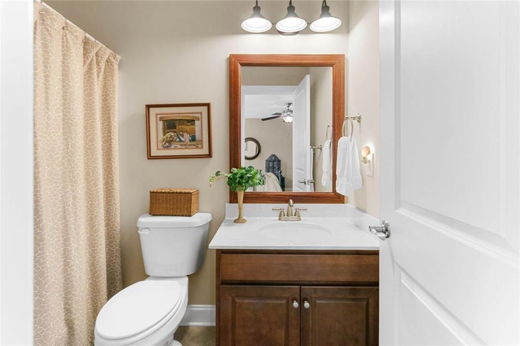 559 Bishopton Street Southeast Grayson, GA 30017 - Photo 30 of 34 a bathroom with a toilet a sink and a mirror