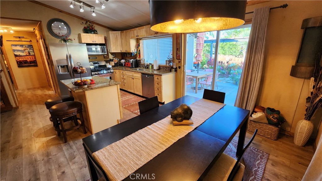 81641 Ave 48, Unit SPC 104 Indio, CA 92201 - Photo 20 of 50 a view of a dining room with furniture a chandelier and wooden floor