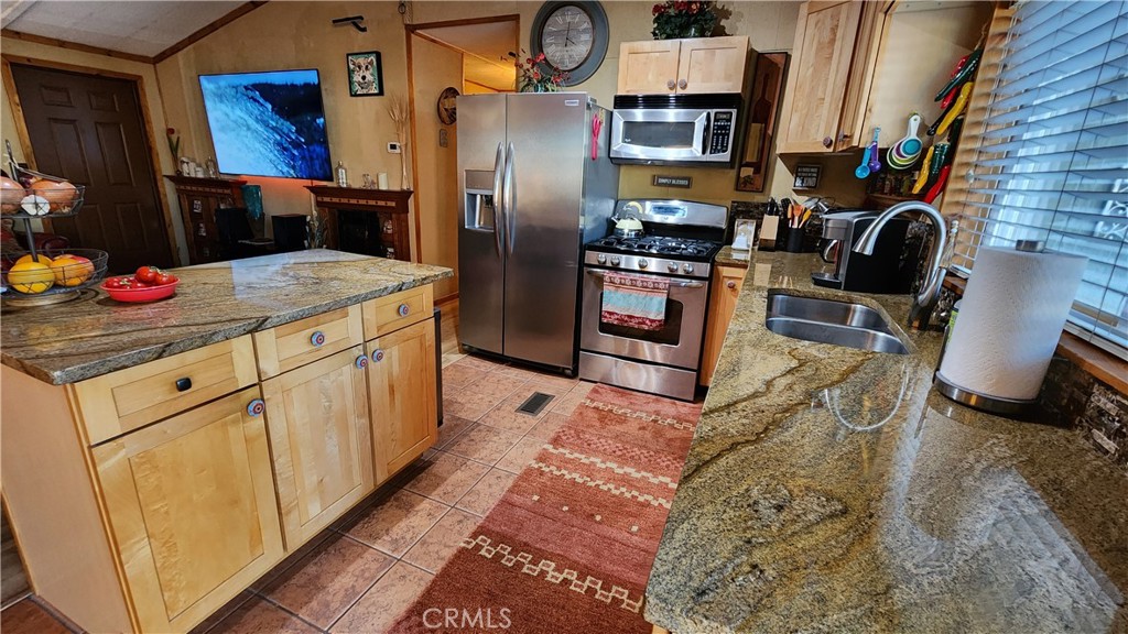 81641 Ave 48, Unit SPC 104 Indio, CA 92201 - Photo 23 of 50 a kitchen with stainless steel appliances granite countertop a refrigerator a stove and a sink with large countertops