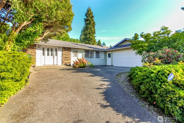 a view of a house with a yard and potted plants