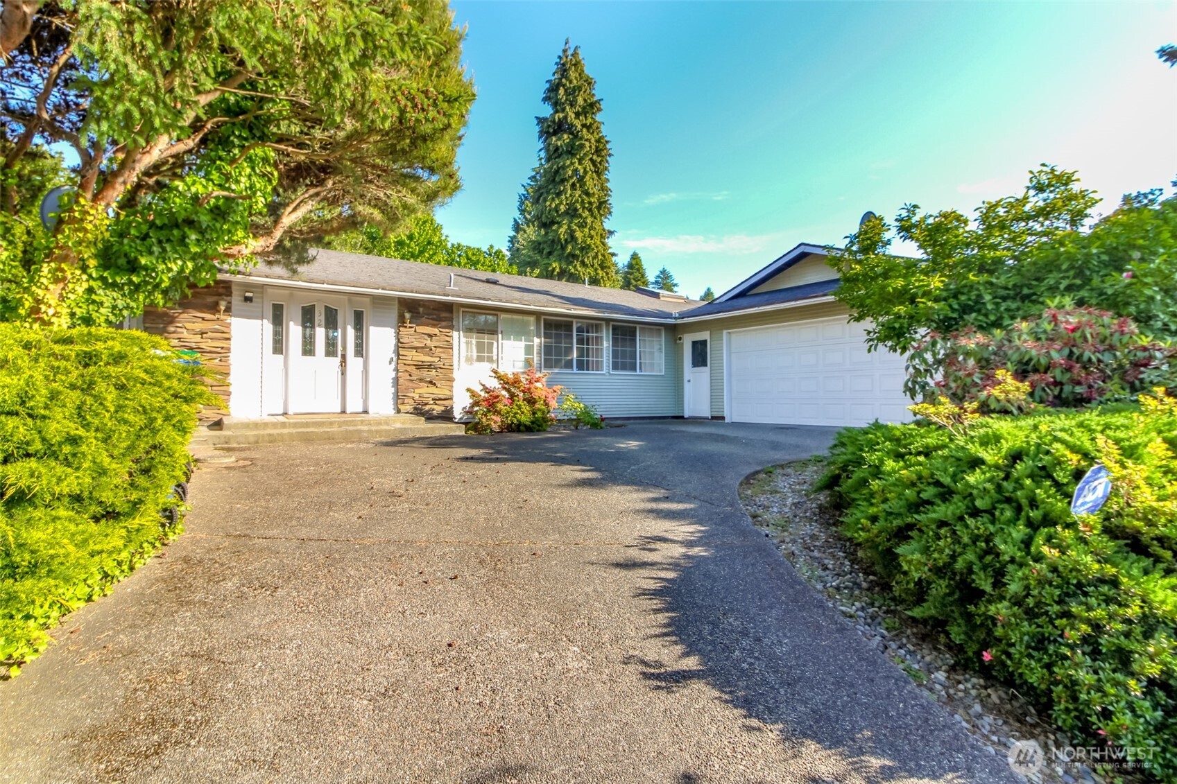 a view of a house with a yard and potted plants
