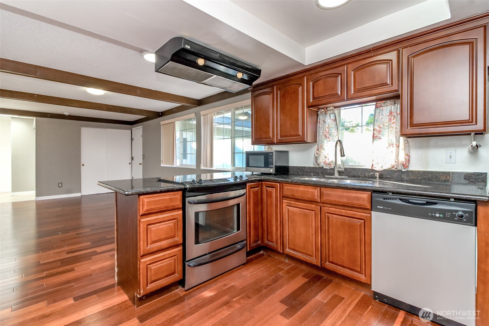 32622 39th Avenue Southwest Federal Way, WA 98023 - Photo 13 of 40 a kitchen with stainless steel appliances granite countertop a stove a sink dishwasher and microwave with wooden floor