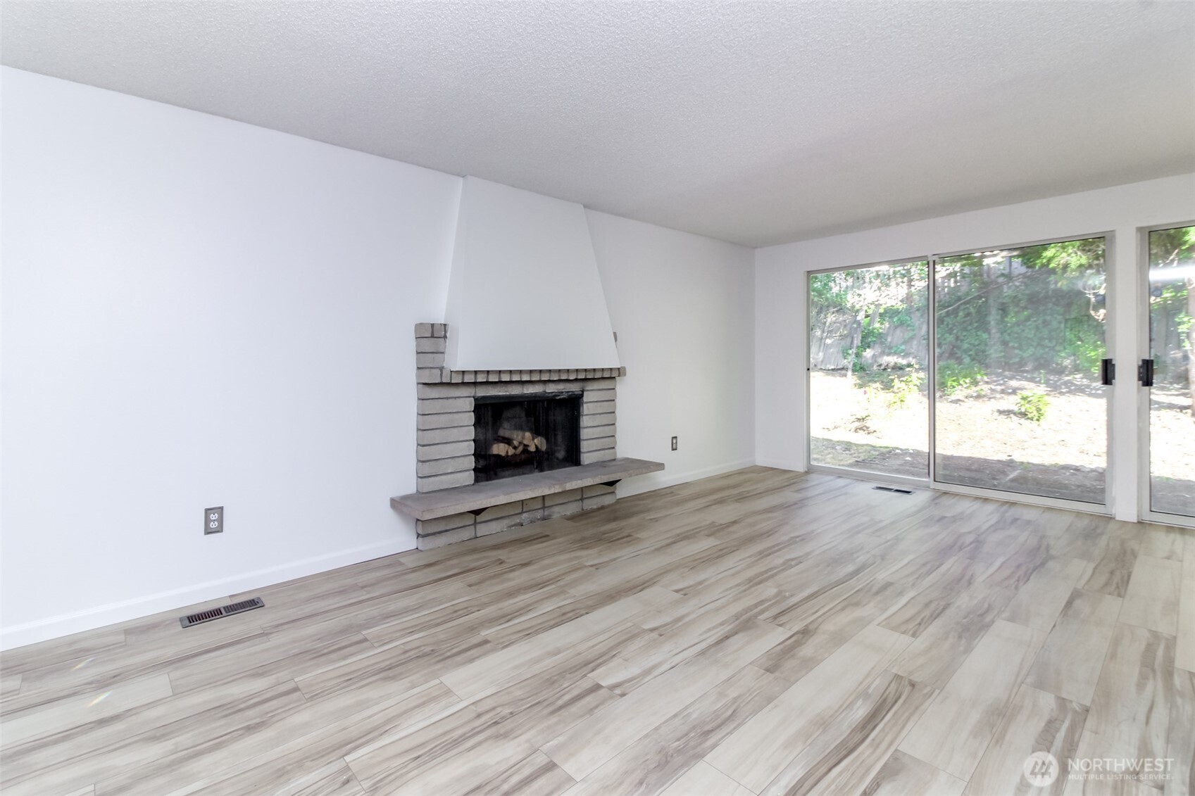 32622 39th Avenue Southwest Federal Way, WA 98023 - Photo 7 of 40 an empty room with wooden floor and a fireplace