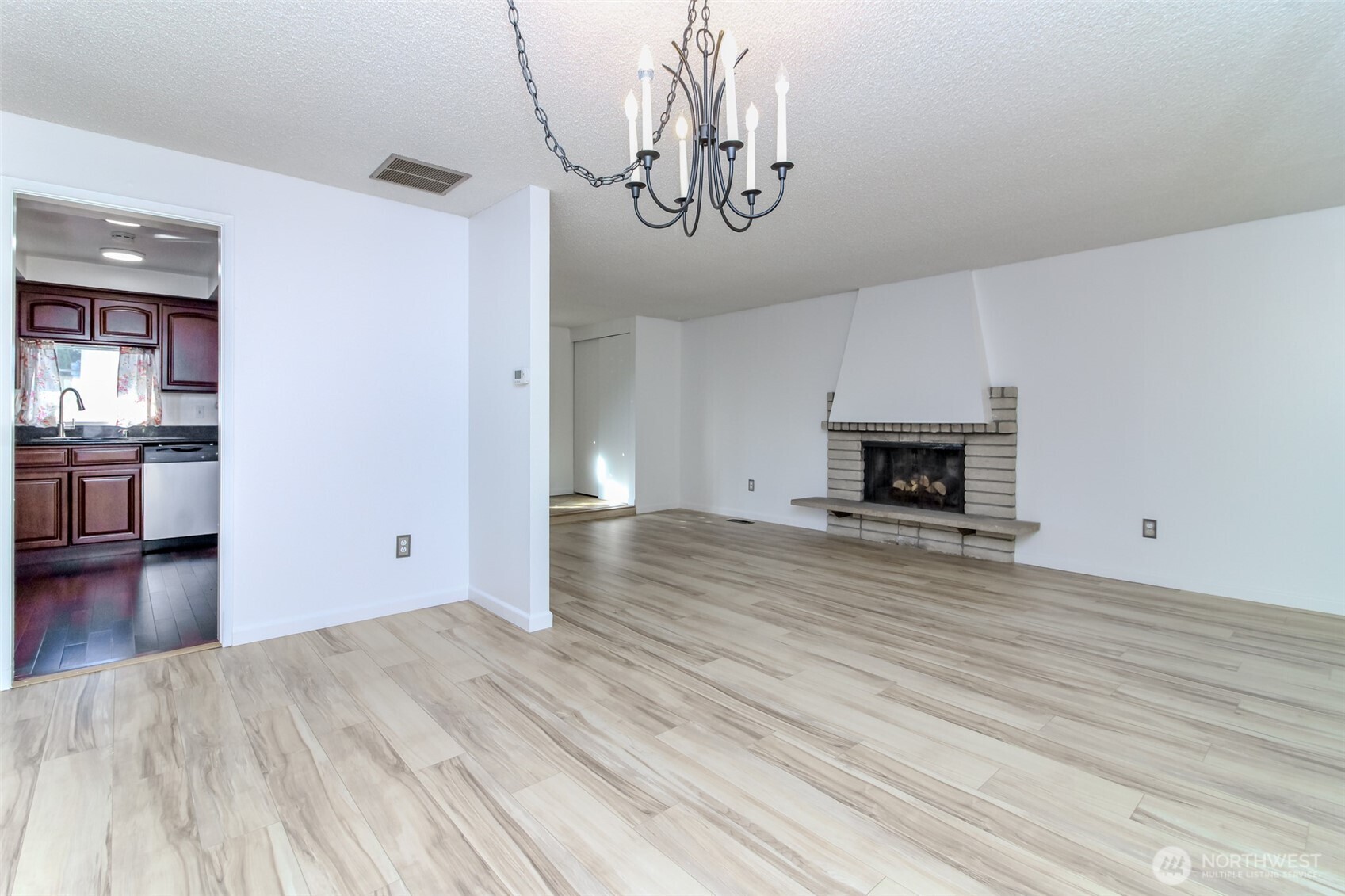 32622 39th Avenue Southwest Federal Way, WA 98023 - Photo 10 of 40 a view of empty room with wooden floor and kitchen view