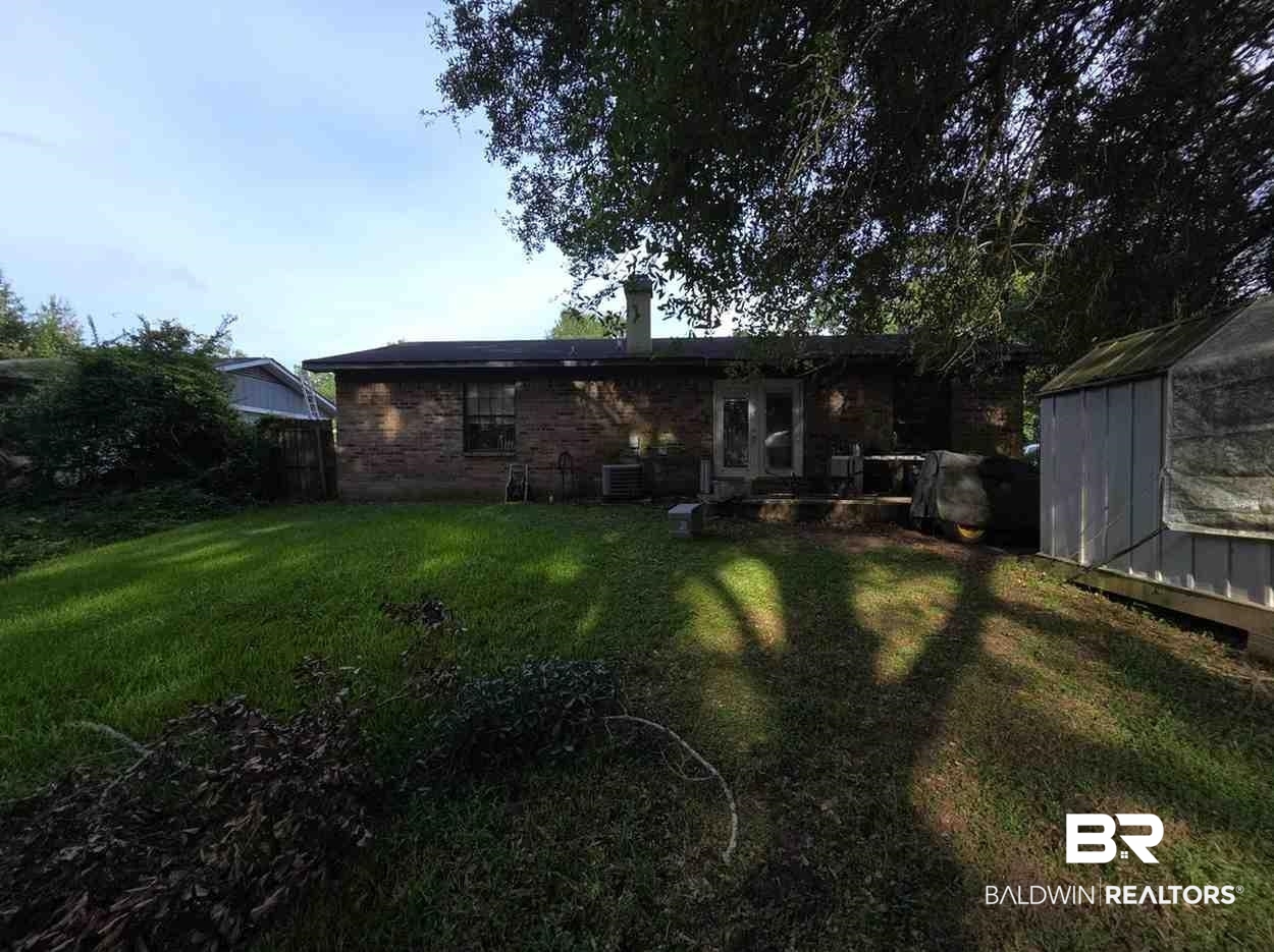 5120 West Celtic Drive Mobile, AL 36619 - Photo 25 of 27 Rear view of property with a chimney, a lawn, a storage unit, and brick siding