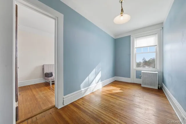 a view of a room with wooden floor and a ceiling fan