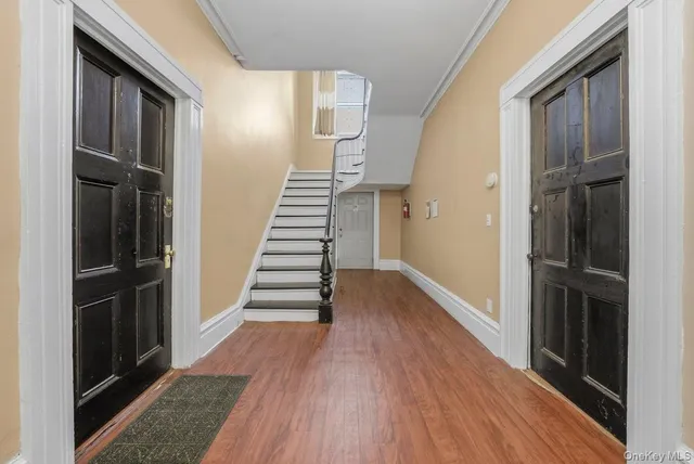 a view of a hallway with wooden floor and staircase