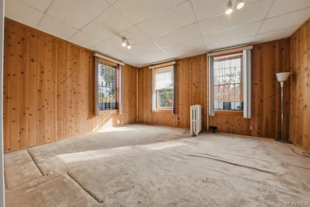a view of an empty room with a window and closet area