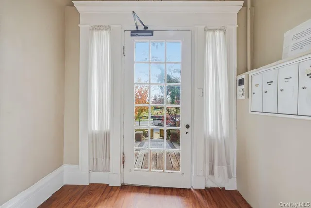 a view of a hallway with wooden floor and entryway