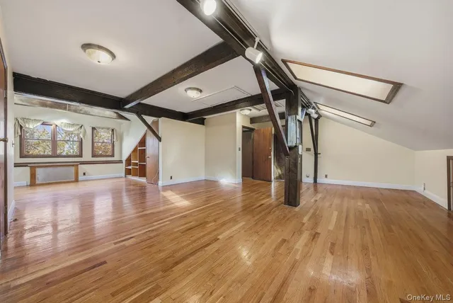 a view of a room with wooden floors and white walls
