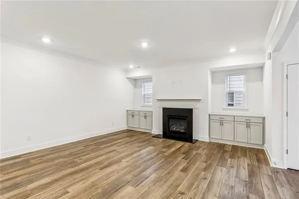an empty room with kitchen and fireplace