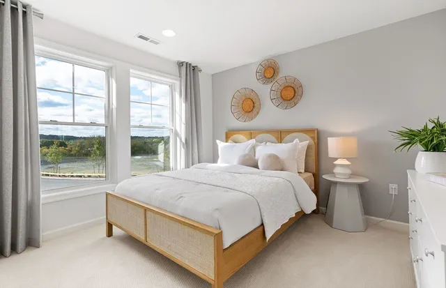 a bedroom with a bed and a large window