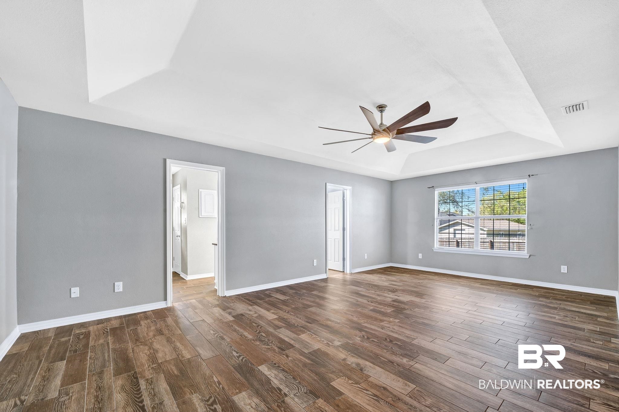 16444 Hamlet Lane Foley, AL 36535 - Photo 24 of 49 master bedroom dark wood-style flooring, visible vents, a tray ceiling, and ceiling fan