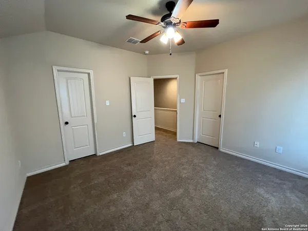 an empty room with closet and a ceiling fan