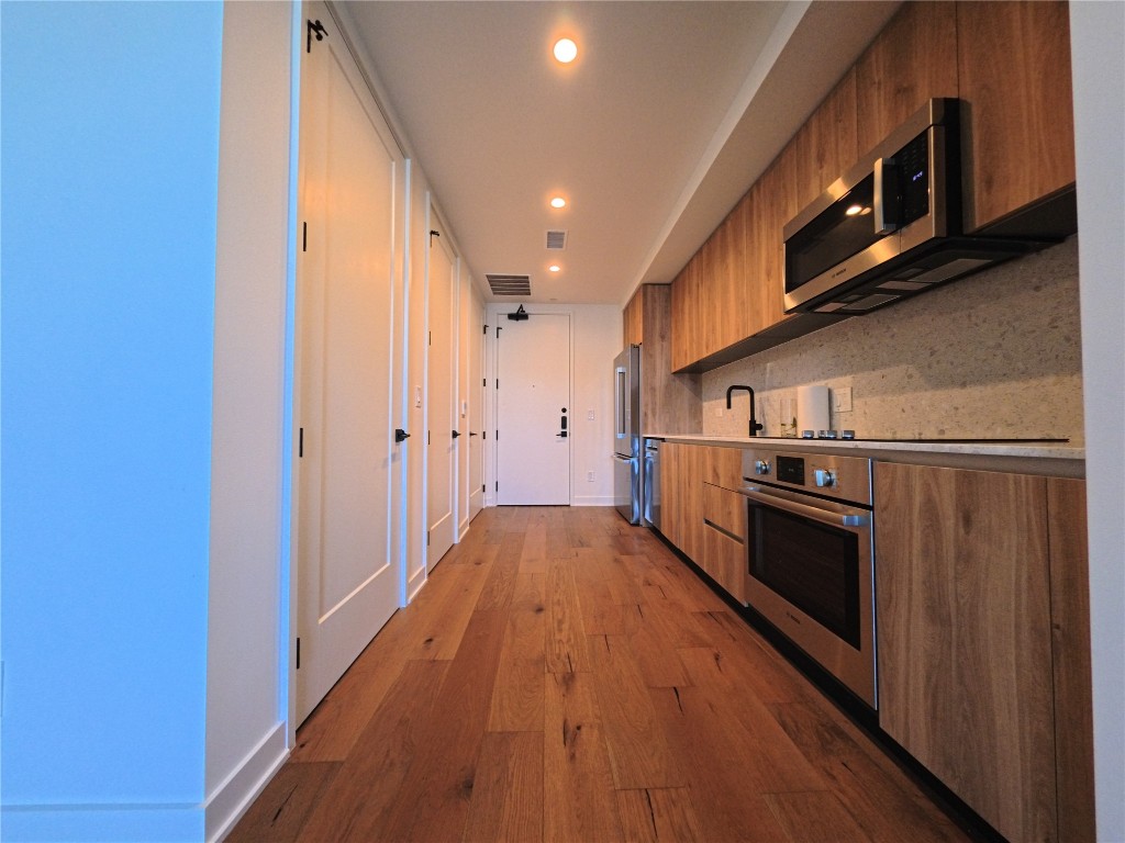 84 East Avenue, Unit 3808 Austin, TX 78701 - Photo 2 of 9 a view of a kitchen with stainless steel appliances granite countertop a refrigerator a stove top oven a sink and dishwasher