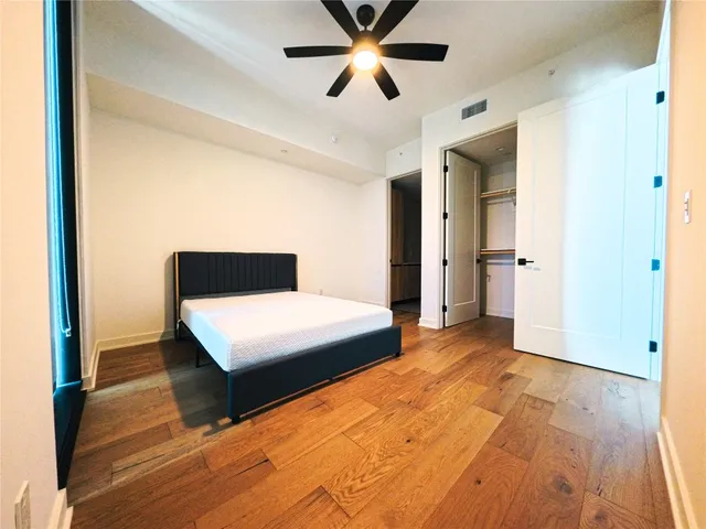 a bedroom with a bed and a ceiling fan