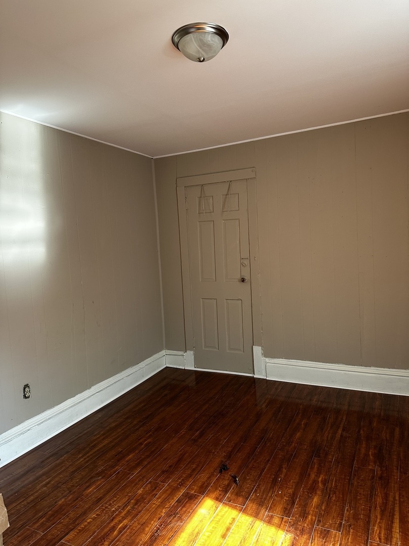 Undisclosed Address Aurora, IL 60505 - Photo 5 of 8 a view of an empty room with wooden floor and a window