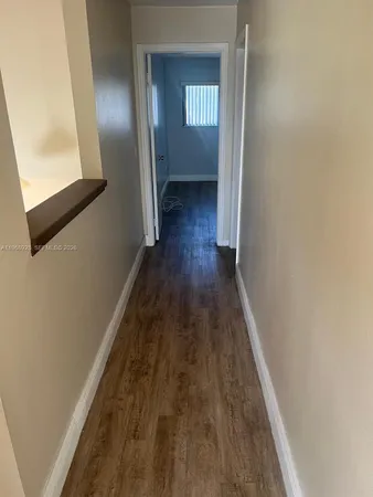 a view of a room with an empty space and a window