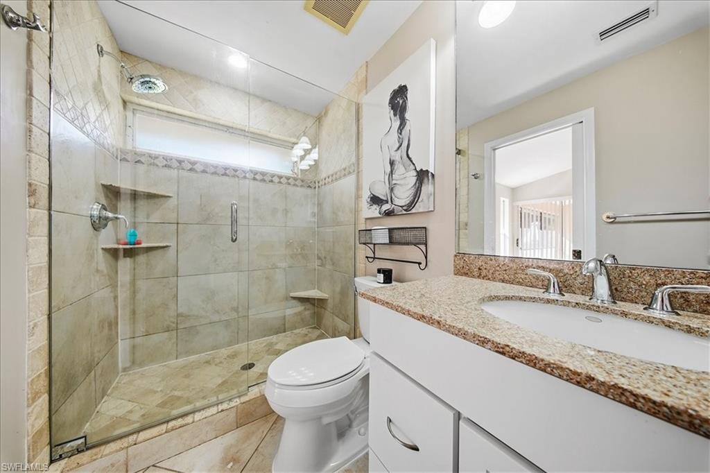 430 St Andrews Boulevard, Unit 6 Naples, FL 34113 - Photo 18 of 47 a bathroom with a granite countertop sink toilet and shower