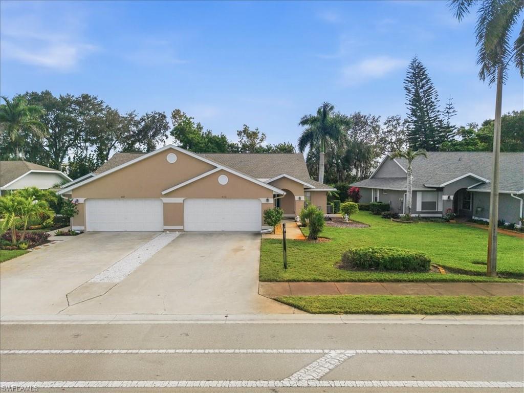 430 St Andrews Boulevard, Unit 6 Naples, FL 34113 - Photo 2 of 47 a view of a house with a big yard plants and large trees