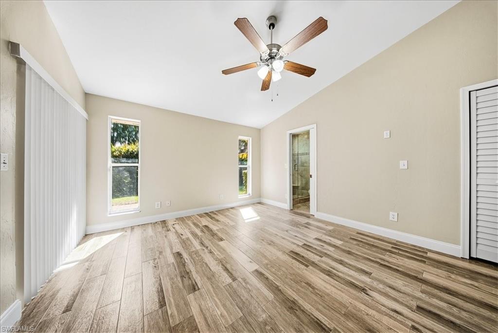 430 St Andrews Boulevard, Unit 6 Naples, FL 34113 - Photo 21 of 47 an empty room with wooden floor and windows