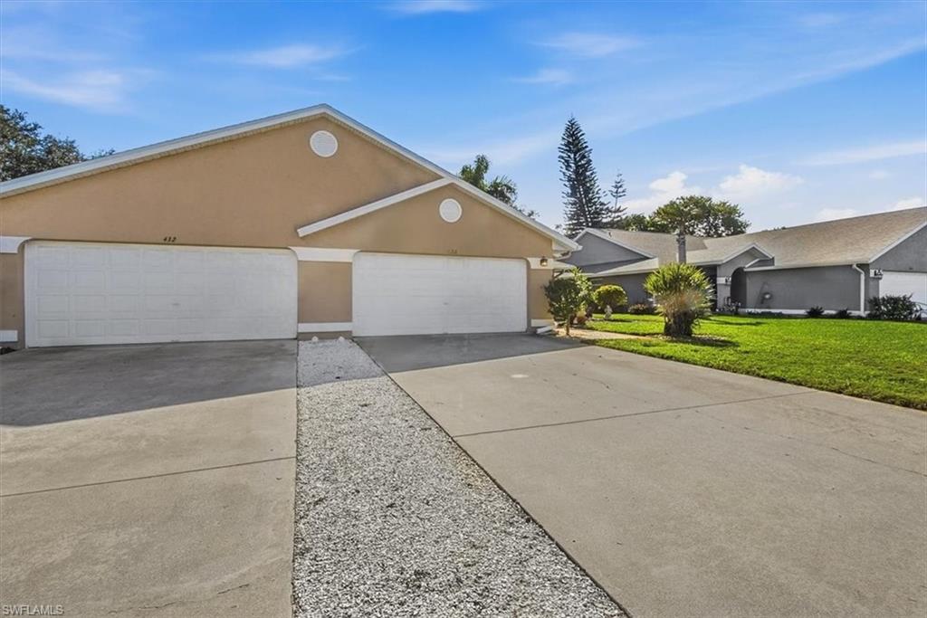 430 St Andrews Boulevard, Unit 6 Naples, FL 34113 - Photo 3 of 47 a front view of a house with a yard and garage