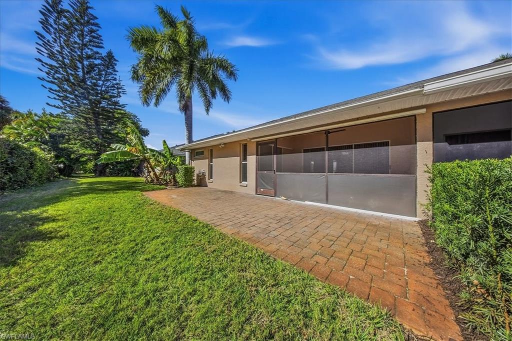 430 St Andrews Boulevard, Unit 6 Naples, FL 34113 - Photo 46 of 47 a front view of a house with a garden and yard