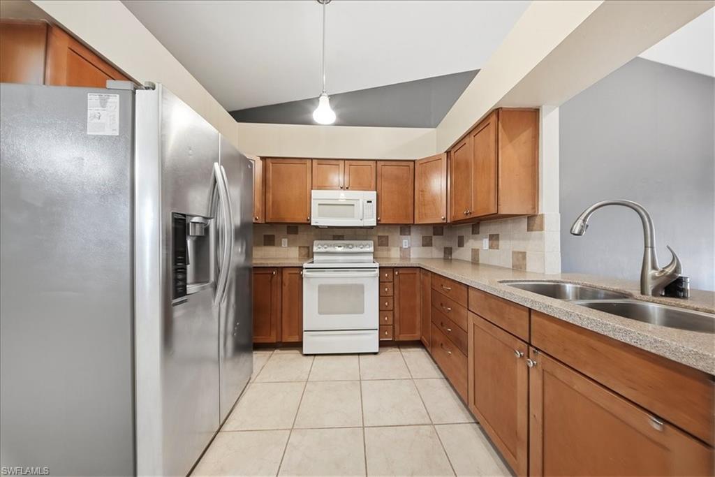 430 St Andrews Boulevard, Unit 6 Naples, FL 34113 - Photo 7 of 47 a kitchen with a sink cabinets stainless steel appliances and a window