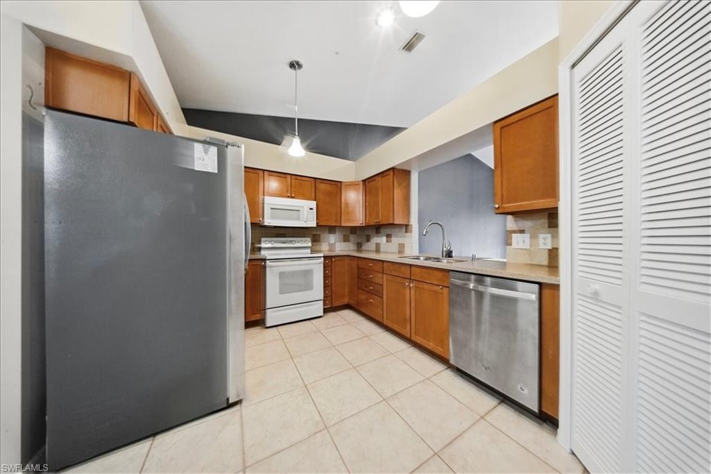 430 St Andrews Boulevard, Unit 6 Naples, FL 34113 - Photo 8 of 47 a kitchen with stainless steel appliances granite countertop a refrigerator and a sink