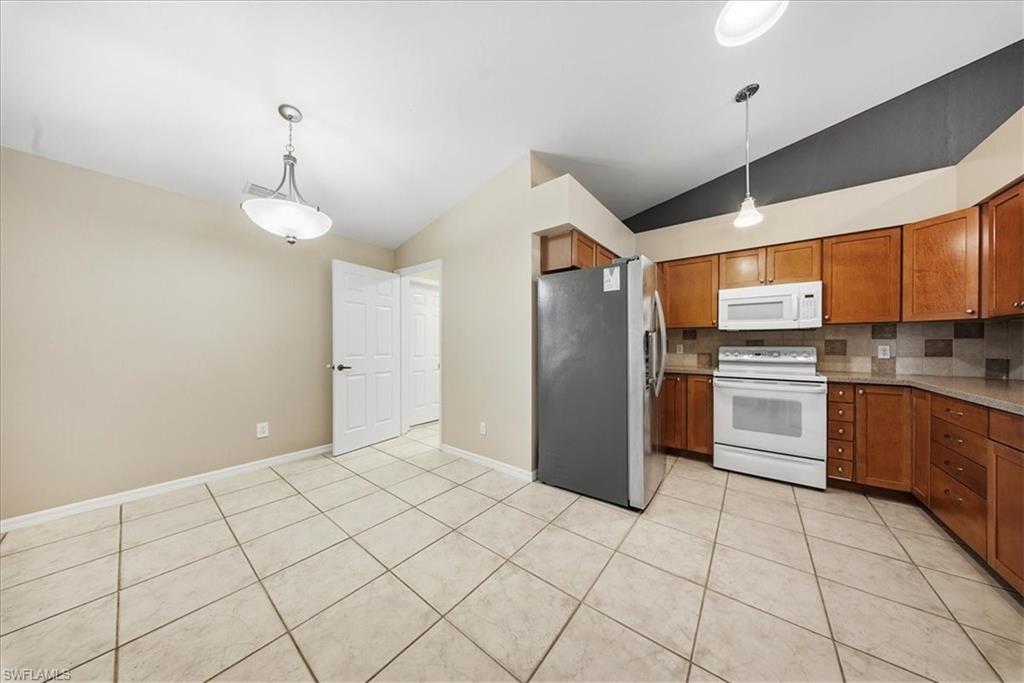 430 St Andrews Boulevard, Unit 6 Naples, FL 34113 - Photo 9 of 47 a kitchen with granite countertop a refrigerator and a stove top oven