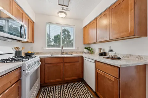 a kitchen with stainless steel appliances granite countertop a stove sink and cabinets