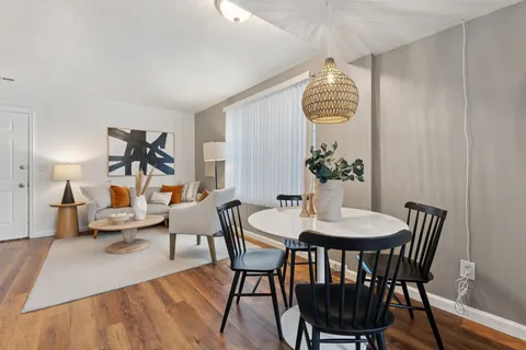 a dining room with furniture a chandelier and wooden floor