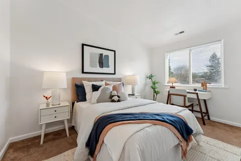 a bedroom with a bed and a large window