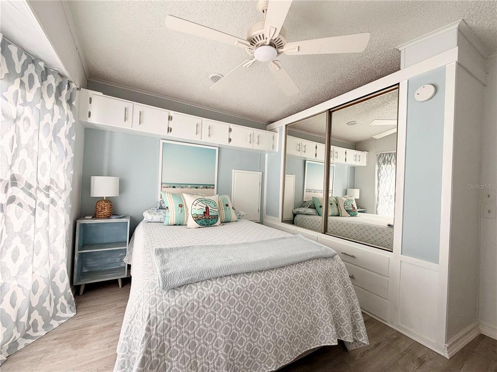 2201 South Ridgewood Avenue, Unit 23 Edgewater, FL 32141 - Photo 3 of 8 a bedroom with a large bed and a chandelier fan