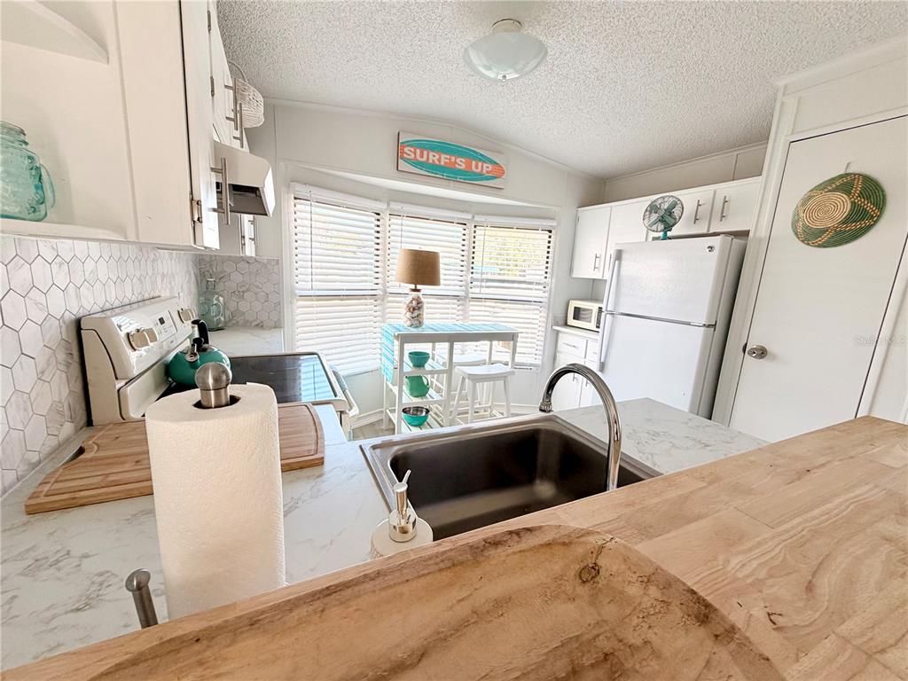 2201 South Ridgewood Avenue, Unit 23 Edgewater, FL 32141 - Photo 4 of 8 a kitchen with a sink a refrigerator and a microwave