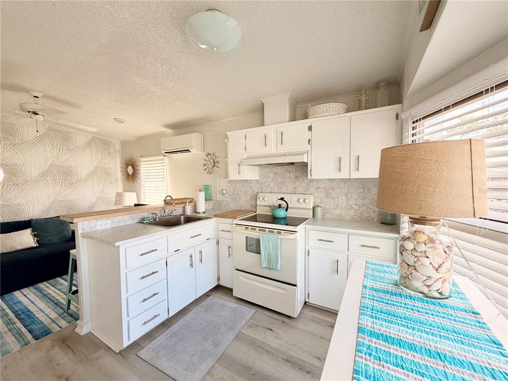 2201 South Ridgewood Avenue, Unit 23 Edgewater, FL 32141 - Photo 5 of 8 a kitchen with granite countertop a sink and white cabinets