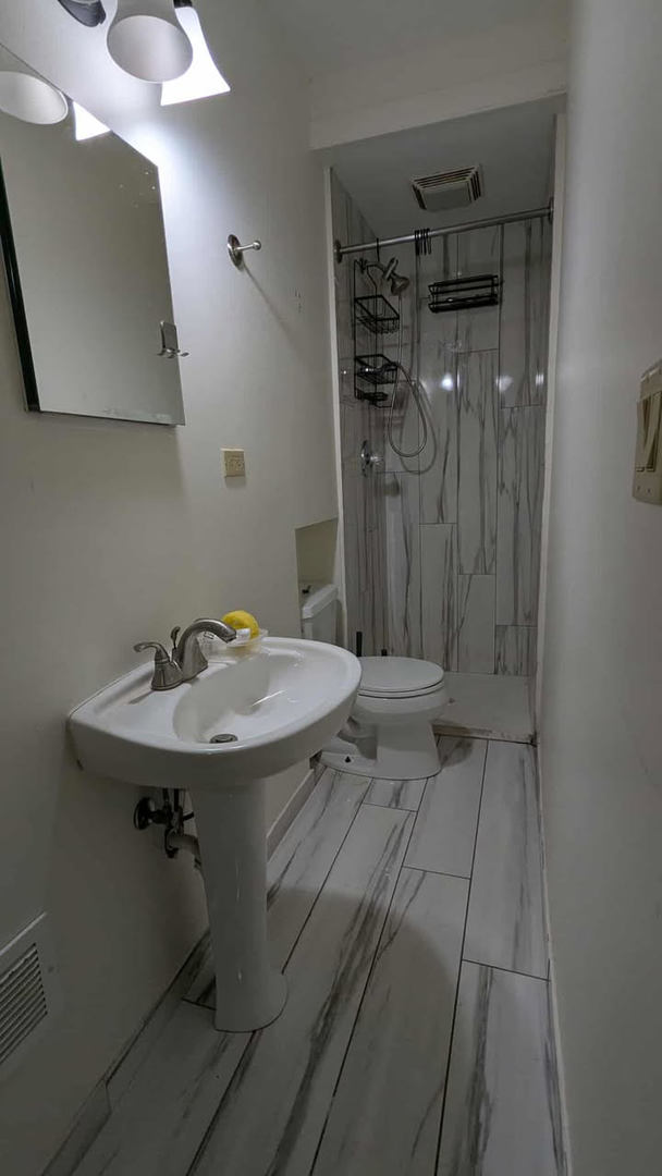 714 Glen Rock Avenue, Unit 3 Waukegan, IL 60085 - Photo 4 of 4 a bathroom with a sink a mirror and shower