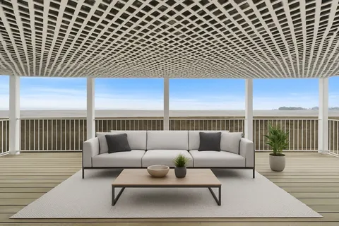 a view of a patio with couches and dining table with wooden floor