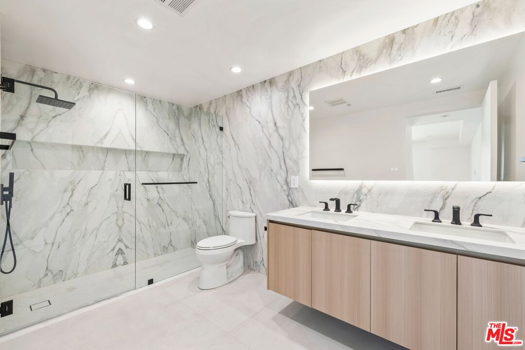 1414 1/2 South Beverly Drive, Unit 402 Los Angeles, CA 90035 - Photo 10 of 15 a bathroom with a double vanity sink toilet and shower