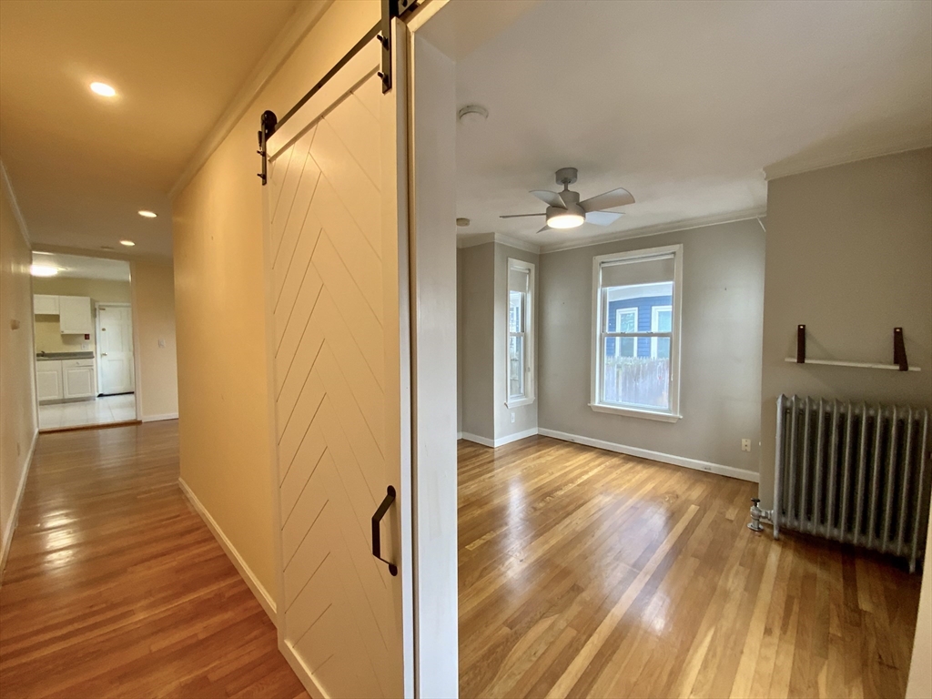 7 Bartlett Avenue, Unit 1 Arlington, MA 02476 - Photo 1 of 1 a view of a hallway with wooden floor and a bathroom